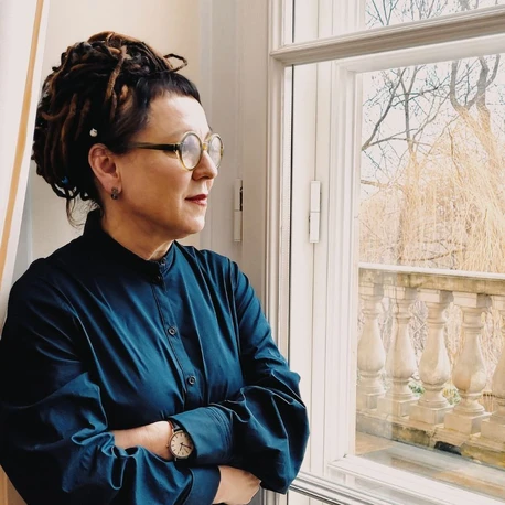 Olga Tokarczuk patrzy przez okno.