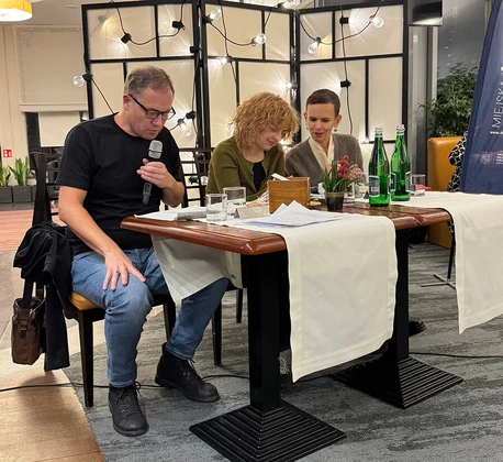 Przy stolikach siedzą członkowie jury